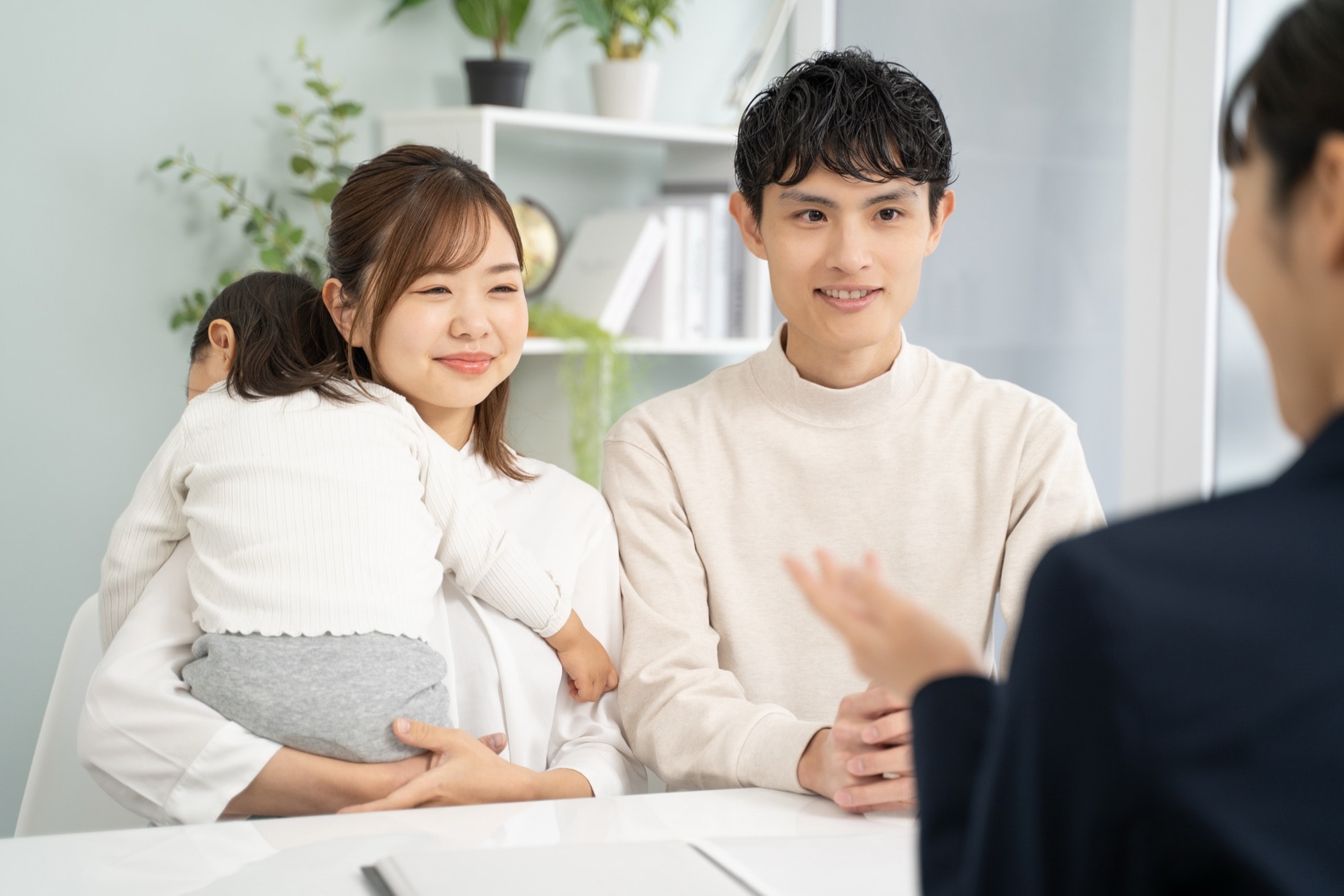 家づくりの費用について解説する住宅専門家の女性と顧客