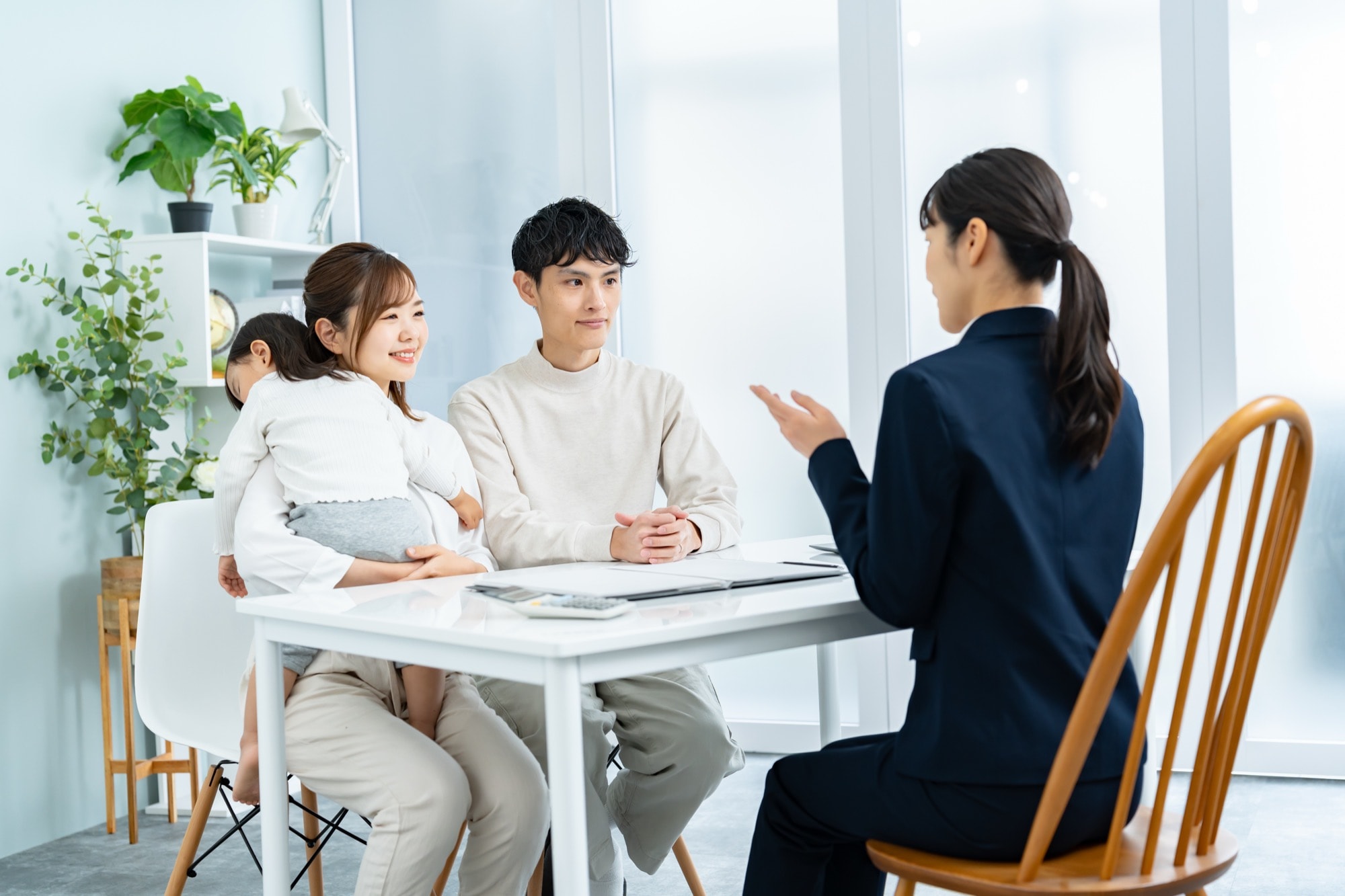 家の買い替えについて住宅会社スタッフに話を聞く夫婦