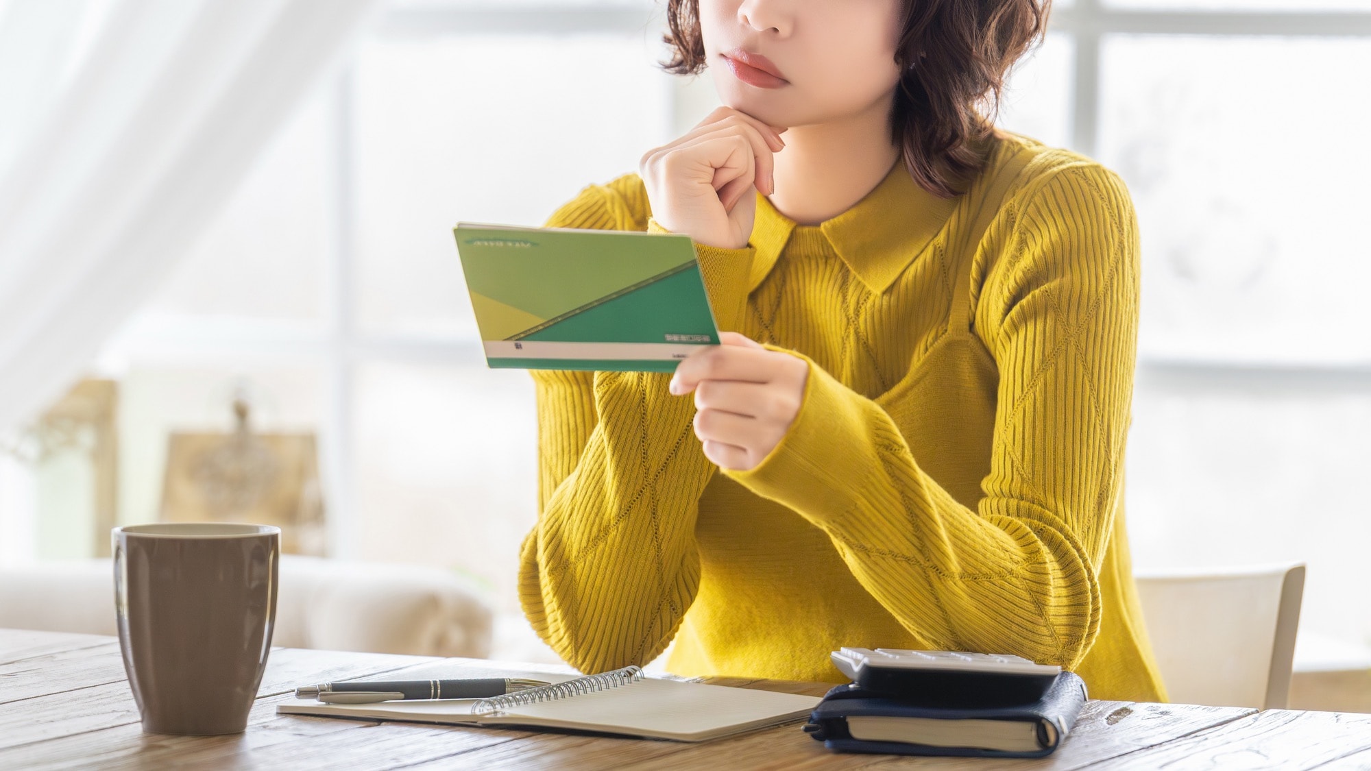 銀行の預金通帳を確認する女性